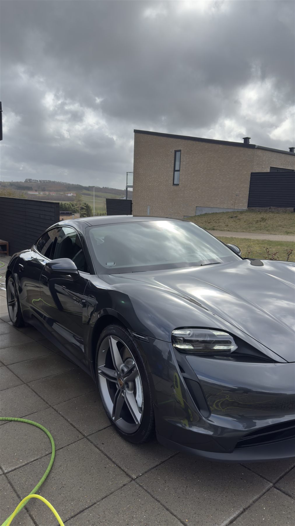 Samme Porsche Taycan efter håndvask, våd og blank lak